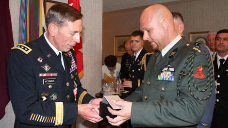 Generaal Petraeus (links) neemt het horloge in ontvangst van Kapitein Marko Kroon